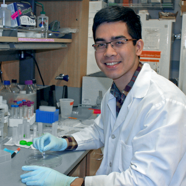 Photo of USRP student John Rodgers in the laboratory, working with petri dishes.