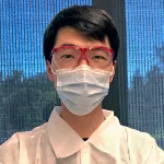Indoor photo of an Asian male graduate student in a wet lab.