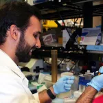 Indoor photo of a white male graduate student in a wet lab.