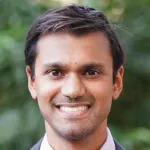 Outdoor headshot photo of a smiling male faculty member, Dr. Anish Mitra, Assistant Professor of Psychiatry at Stanford University.