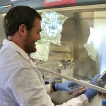 Indoor photo of a white male graduate student in a wet lab.