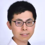 Indoor headshot photo of a smiling Asian male faculty member, Dr. Haopeng Xiao, Assistant Professor of Biochemistry at Stanford University.