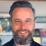 Photo of smiling white male faculty member with a thick gray beard, Dr. Jeffrey Hancock, Professor of Communications at Stanford University.