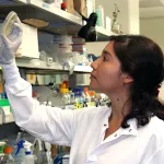 Indoor photo of a Latina female graduate student in a wet lab.