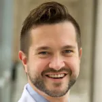 Headshot photo of a smiling white male faculty member with short dark hair and a short dark beard, Dr. Mitchell Lunn, Associate Professor of Medicine at Stanford University.