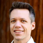 Headshot photo of a smiling white male faculty member with short dark hair, Dr. Nathan Reticker-Flynn, Assistant Professor of Otolaryngology at Stanford University.