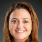 Photo of a smiling female faculty member with shoulder-length red-brown hair, Dr. Raya Saab, Professor of Pediatrics at Stanford University.