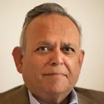 Indoor headshot photo of a male faculty member, Dr. Shripad Tuljapurkar, Professor of Biology at Stanford University.