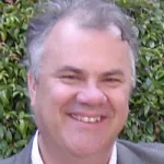 Outdoor headshot photo of a smiling male white faculty member, Dr. James Nelson, Professor Emeritus of Biology at Stanford University.