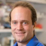 Indoor headshot photo of a smiling white male faculty member, Dr. Zev Bryant, Associate Professor of Bioengineering at Stanford University.