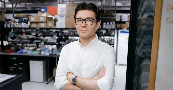 Indoor photo of a male faculty member standing inside of a wet laboratory.