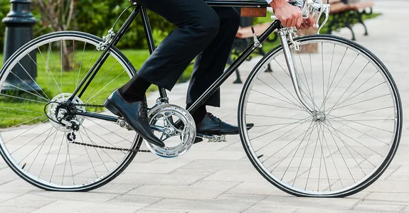 Photo of a man bicycling across courtyard.