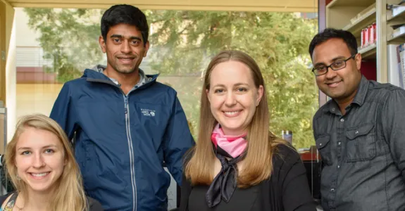 Photo of graduate students Kiah Hardcastle and Niru Maheswaranathan and Drs. Lisa Giocomo and Surya Ganguli in laboratory space.