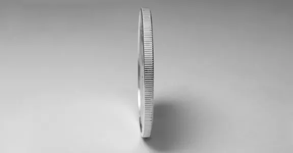 Photo of coin standing on its edge.