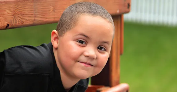 Photo of a young Latino boy playing outdoors.