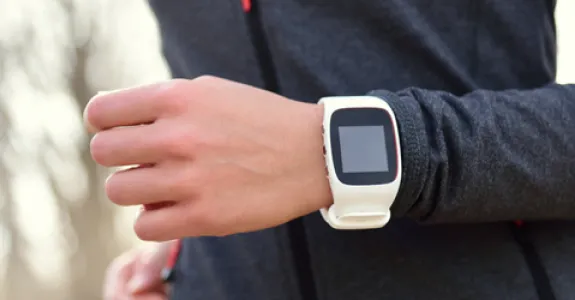 Photo of woman running wearing an Apple watch.