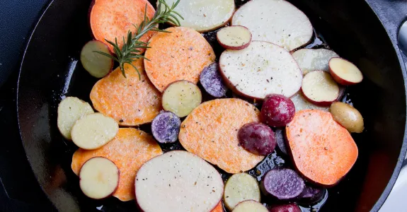 Photo of colorful potatoes being cooked in a pan.