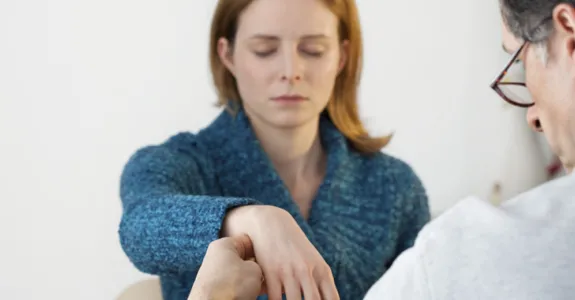 Photo of woman having pulse monitored during hypnotic treatment.