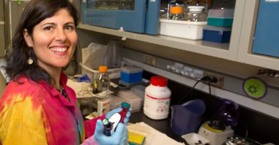 Photo of Dr. Desiree LaBeaud in the laboratory pipetting.