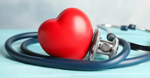 Photo of a plastic heart with a stethoscope wrapped around it.