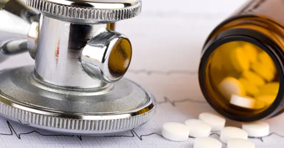 Photo of stethoscope and medication bottle.