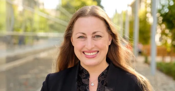 Outdoor photo of a smiling white female faculty member with long blonde hair.