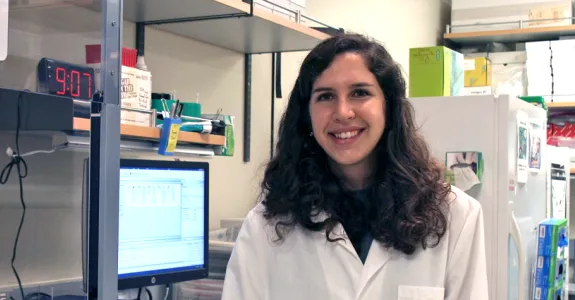 Photo of smiling female graduate student in a wet laboratory.