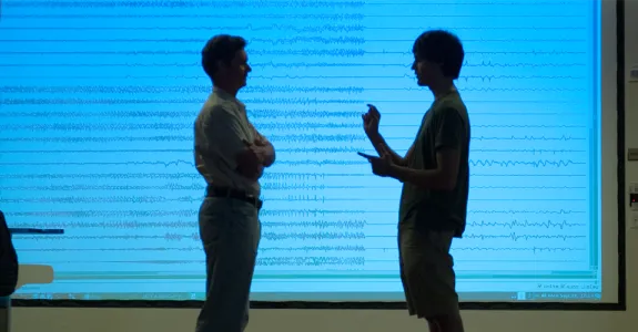 Photo by L.A. Cicero: Professor Chris Chafe and undergraduate researcher Michael Iorga discuss the patterns of brain activity seen in the graphic representation of the seizure as recorded by multiple electrodes.
