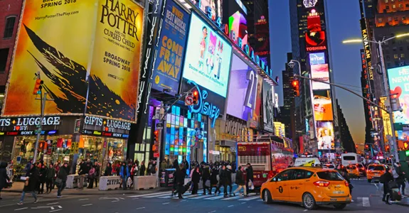Photo of busy New York City intersection at night.