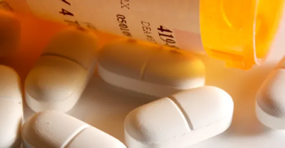 Photo of a medicine bottle spilling pills.