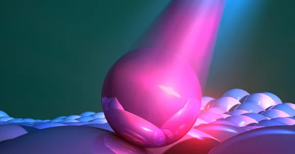 Graphic image depicting a large pink sphere colliding with a surface to represent a quantum dot.