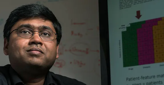 Photo of Dr. Nigam Shah with a graph on the projector behind him.