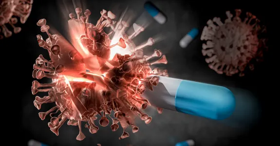 Digital illustration of a COVID virus molecule being struck by a blue and white pill and breaking apart.