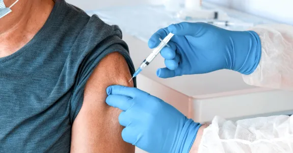 Photo of an elderly man receiving a vaccine injection.