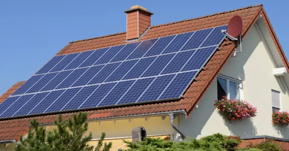 Photo of a house with numerous solar panels on the roof.