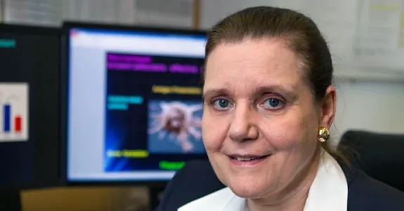 Photo of Dr. Connie Weyand in her office with computers in the background.