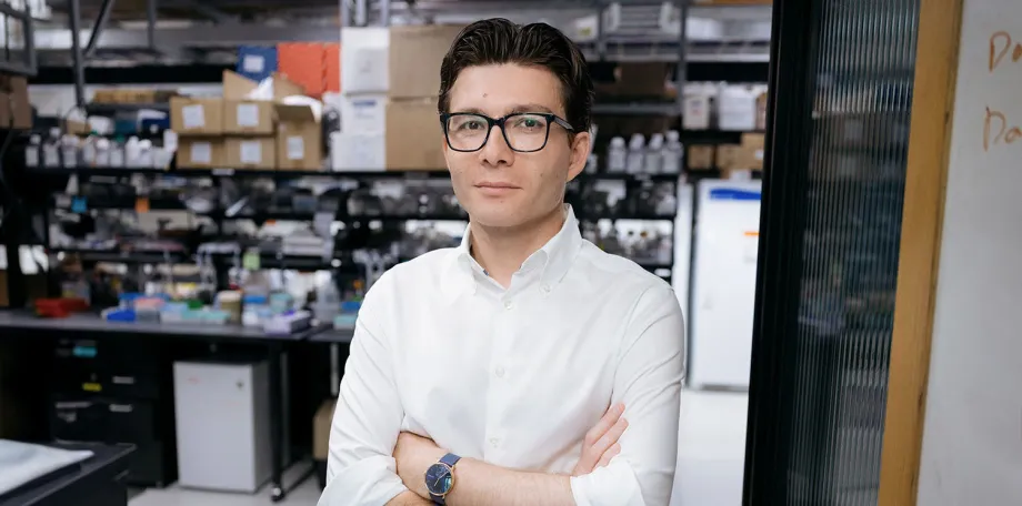 Indoor photo of a male faculty member standing inside of a wet laboratory.