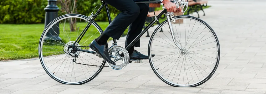 Photo of a man bicycling across courtyard.
