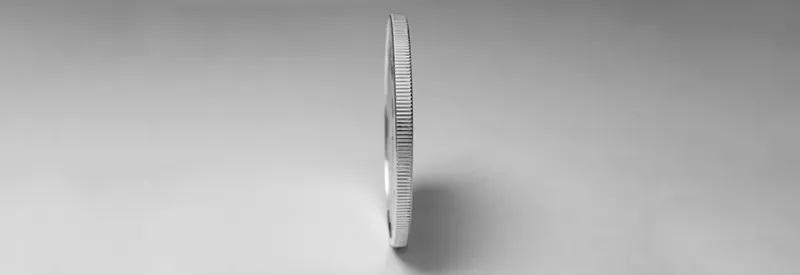 Photo of coin standing on its edge.