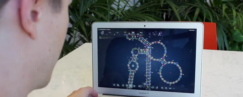 Screenshot of a student looking at the Eterna game on a laptop screen, with a folding protein depicted in bright colors.