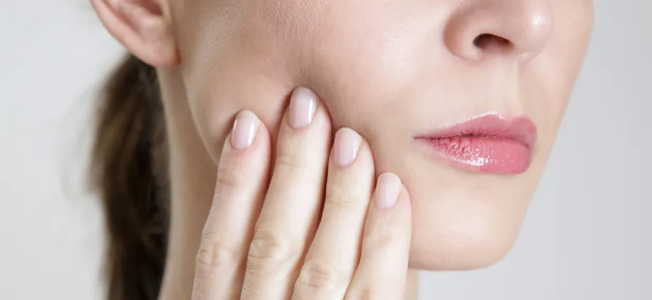 Stock photo of a woman touching her cheek.