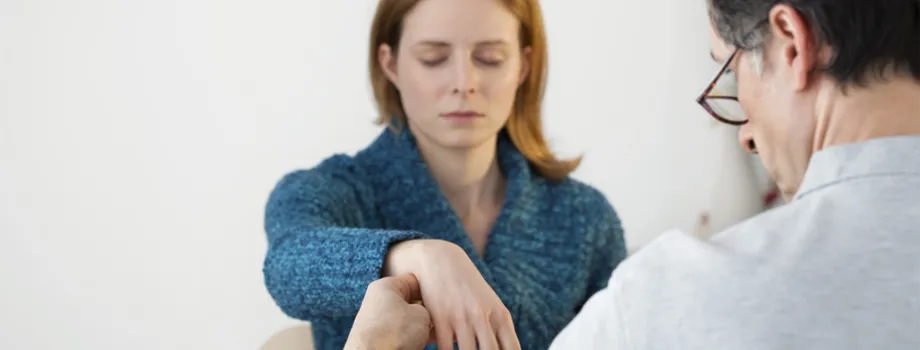 Photo of woman having pulse monitored during hypnotic treatment.