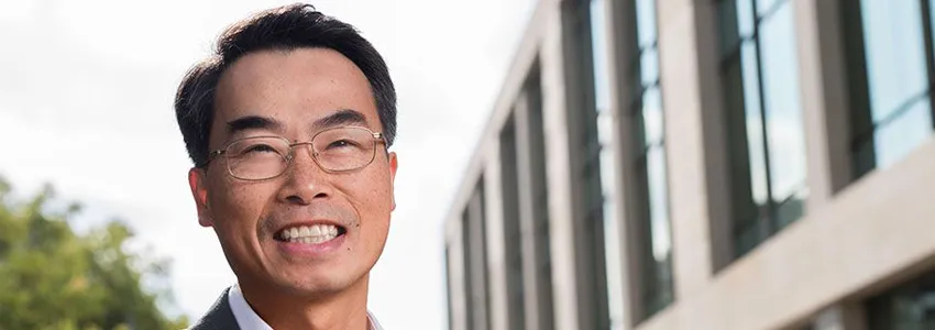 Photo of Dr. Joseph Wu in front of a building with many windows.