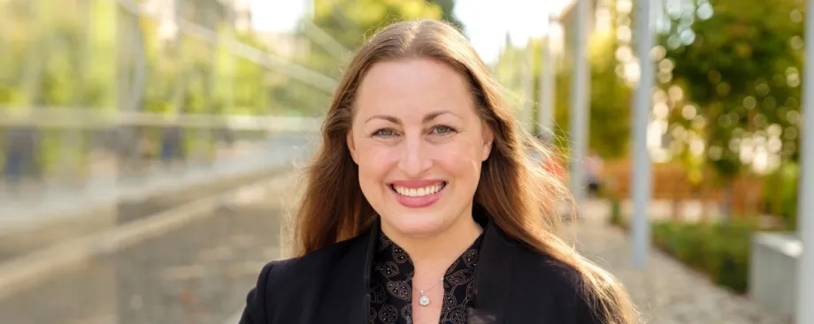 Outdoor photo of a smiling white female faculty member with long blonde hair.