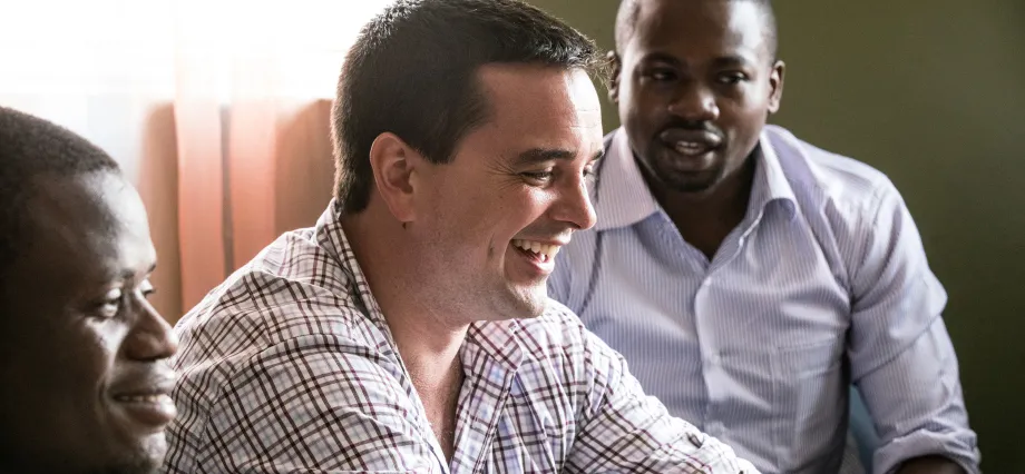 Photo of Dr. Mike Baiocchi laughing with two colleagues in Kenya.