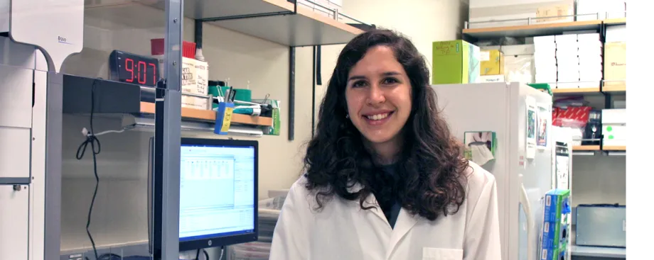 Photo of smiling female graduate student in a wet laboratory.