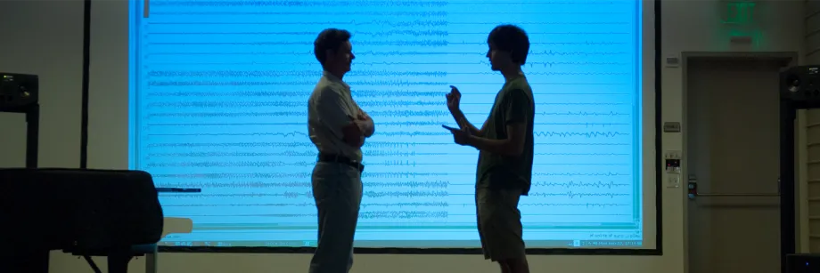 Photo by L.A. Cicero: Professor Chris Chafe and undergraduate researcher Michael Iorga discuss the patterns of brain activity seen in the graphic representation of the seizure as recorded by multiple electrodes.