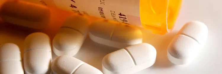 Photo of a medicine bottle spilling pills.