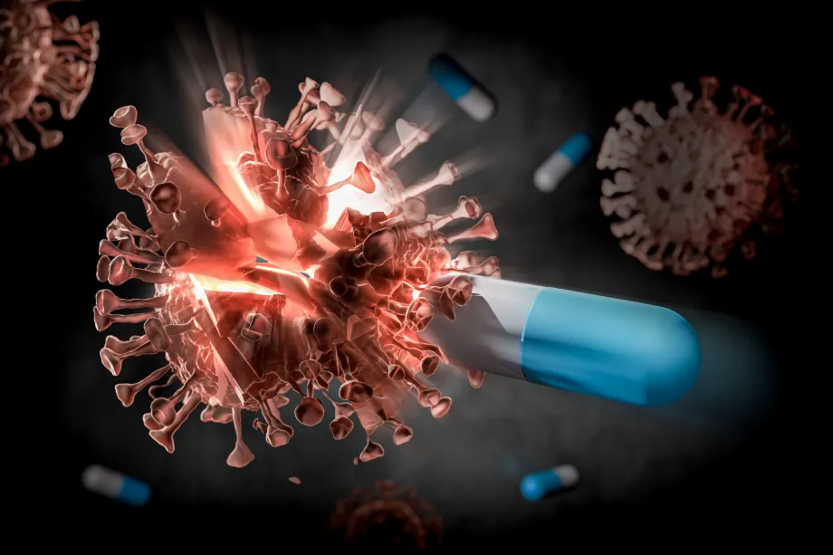 Digital illustration of a COVID virus molecule being struck by a blue and white pill and breaking apart.