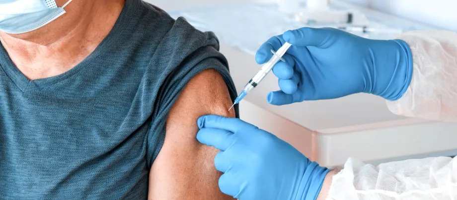Photo of an elderly man receiving a vaccine injection.